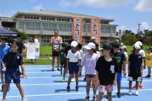 譜久里さん（奥）から指導を受ける子どもたち＝12日、多良間中グラウンド