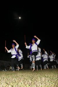 満月の下、男性たちは力強く棒を振った＝９月29日、上野野原の野原公民館