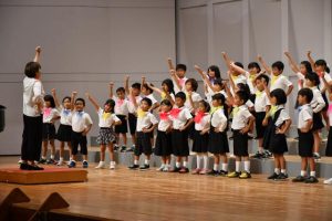 下地小2年生は全身を使った合唱奏を披露した＝3日、マティダ市民劇場