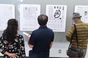 「宮古の新聞展」が開幕。来場者は過去の新聞のパネルを見て思い出などを語っていた＝14日、市立図書館