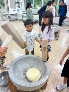 協力して餅つきを楽しむ児童たち＝9日、福嶺小ランチルーム