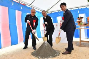 工事の安全を祈願してくわ入れする（左から）黒島会長、座喜味市長、石井執行役員＝16日、平良荷川取