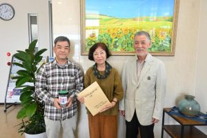 展示会で集まった募金に感謝する（左から）平良さん、佐渡山さん、池田さん＝２日、宮古毎日新聞社