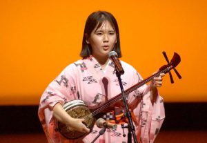 「豆が花」と「うつにーまぬかながま」を歌い上げた與儀さん＝３日、うるま市の石川会館