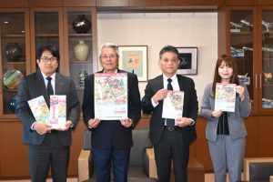 座喜味市長に５年ぶりの宮古島公演開催を報告する仲田社長（左）ら関係者＝13日、市役所