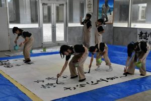 書道パフォーマンスを披露する児童生徒たち＝24日、市未来創造センター