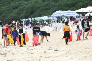 約５００人が参加し、漂着ごみなどを拾い集めた「ほっとけないプロジェクト」＝６日、新城海岸
