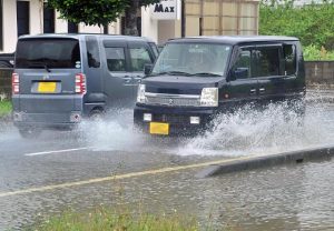水しぶきを上げながら走る車＝８日、平良東仲宗根（写真は一部加工してあります）