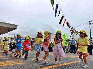 頭上で園児たちが手作りしたこいのぼりが泳ぐ中、元気なダンスを披露した「鯉のぼり作戦」＝24日、宮古島署