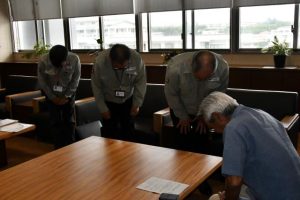 座喜味市長（右）に改めて謝罪する比嘉支店長（右から２人目）、平良隆博同支店配電サービスグループ長（同３人目）ら＝２６日、市役所