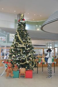 カウンター前には大きなクリスマスツリーが飾られている＝30日、市立図書館