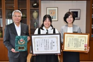 座喜味市長と大城教育長に厚生労働大臣賞受賞を報告する上原さん(中央)=27日、市役所