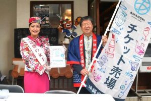 イベントＰＲしチケット販売も行った新垣専務理事（右）と泡盛の女王喜友名さん＝30日、西里通り