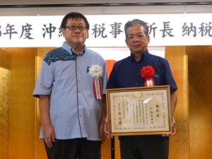 国税庁長官表彰を受けた下地さん（右）と沖縄国税事務所の児島所長＝12日、那覇市