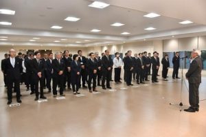 仕事納めの会で座喜味市長の訓示に聞き入る幹部職員ら＝27日、市役所大ホール