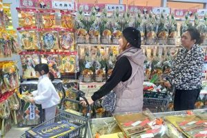 正月用の飾り付けを品定めする買い物客＝28日、マックスバリュ宮古南店