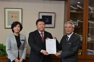 辞令を交付した座喜味市長（右）と再任された中尾さん（中央）、同席した大城教育長＝５日、市役所