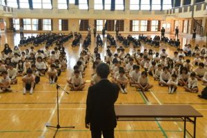 佐久本校長が２学期を振り返り、児童生徒の活躍をたたえた終業式＝25日、伊良部島小中体育館