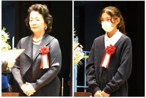 教育功労者の本永さん（左）、模範児童生徒の大渕さんを表彰した宮古島市の教育を語る市民大会＝16日、市未来創造センター多目的ホール