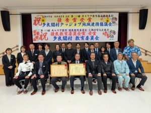 キャリア教育推進連携表彰優秀賞と優良教育委員会賞のW受賞を報告した村の教育関係者=10日、村コミュニティー施設ふれあいフクギ館