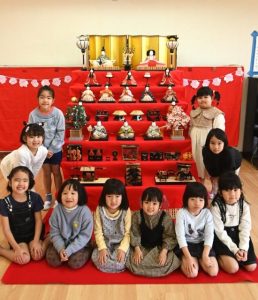 ひな人形を前に笑顔の園児たち＝27日、南幼稚園