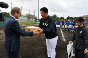 嘉数市長（左）が黒糖１箱を金剛監督に贈呈した＝18日、下地球場