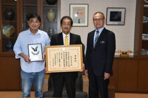 宮古初の厚生労働省健康・生活衛生局長賞を受賞した福嶺さん（中央）と村吉支部長（左）、報告を受けた嘉数市長＝４日、市役所