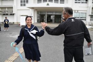 高校入試を終えて教諭と笑顔でハイタッチする受験生＝５日、宮古高校