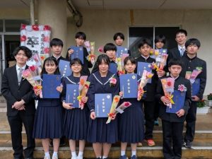 卒業証書と花束を胸に晴れやかな表情を見せる卒業生の皆さん=7日、多良間中体育館