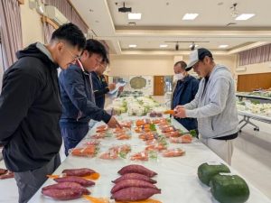 出品された野菜を審査する審査員ら＝２月２４日、村コミュニティーセンター