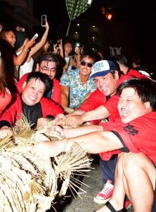 こん身の力で綱を引く東軍。2勝1敗で昨年の雪辱を果たした＝26日夜、市公設市場前交差点