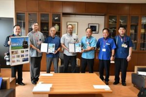 切手フレームを手渡す与那覇局長（右から３人目）ら＝７日、市役所