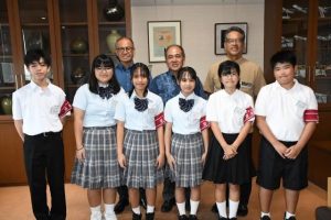 嘉数市長（後列左）、宮城教育長（同右）を表敬訪問し取材活動に意欲を示す豆記者の皆さん＝24日、市役所