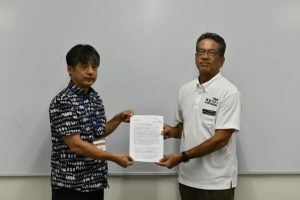 友利執行委員長（左）から要請書が宮城教育長に手渡された＝23日、市役所