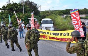 徒歩防災訓練に抗議の声を挙げる市民団体のメンバーら＝５日、伊良部の長山港