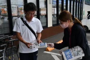 号外を受け取る市民ら＝23日、平良久貝のスーパーマーケット