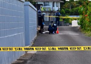 女性が倒れていた場所では警察官による鑑識作業が行われていた＝20日、伊良部長浜