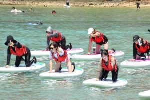 サップヨガを楽しむ参加者たち＝２日、シギラビーチ