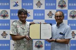 嘉数市長（右）から空家等管理活用支援法人の指定書が安里理事長に手渡された＝6日、市役所