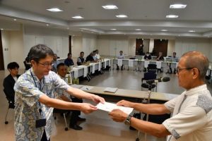 委嘱状を手渡す嘉数市長（右）＝27日、市役所
