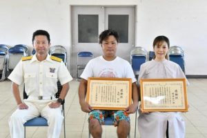 丹野部長（左）から感謝状を受け取った匠さん（中央）と植田さんの代理、綾乃さん＝21日、宮古島漁協