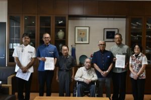 嘉数市長（左から２人目）と宮城克典教育長（右から２人目）にハンセン病問題への取り組みを要請した関係者ら＝25日、市役所