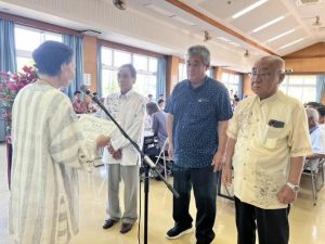 砂川会長（左）が優秀な成績を挙げた生産農家をたたえ賞状を贈った共進会＝３日、保良公民館