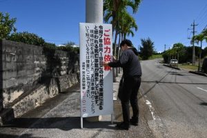 宮古島署の職員が現場付近に看板を設置した＝28日、伊良部長浜
