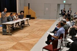 座談会で市民の質問に答えるパネリストら＝13日、市未来創造センター多目的ホール