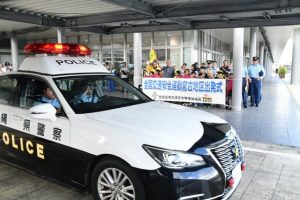 嘉数市長や子供たちに見守られて出発するパトカー