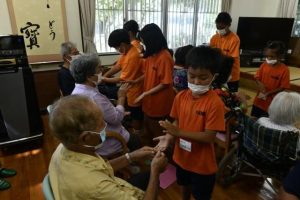 利用者と児童たちがゲームを楽しんだ＝18日、小規模多機能型居宅介護事業所ぷくんみ