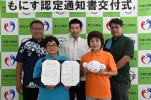 中島部長（中央）から交付を受けた藤井代表理事（手前左）と池間恵美副理事（同右）＝９日、宮古公共職業安定所