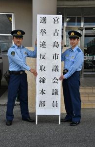 新垣署長（右）と新垣徹刑事課長が取締本部の看板を設置した＝３日、宮古島署