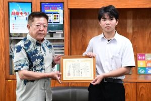 第32回新聞配達に関するエッセーコンテストで入選した林さん(右)と表彰状を伝達した山内社長=10月31日、北中学校